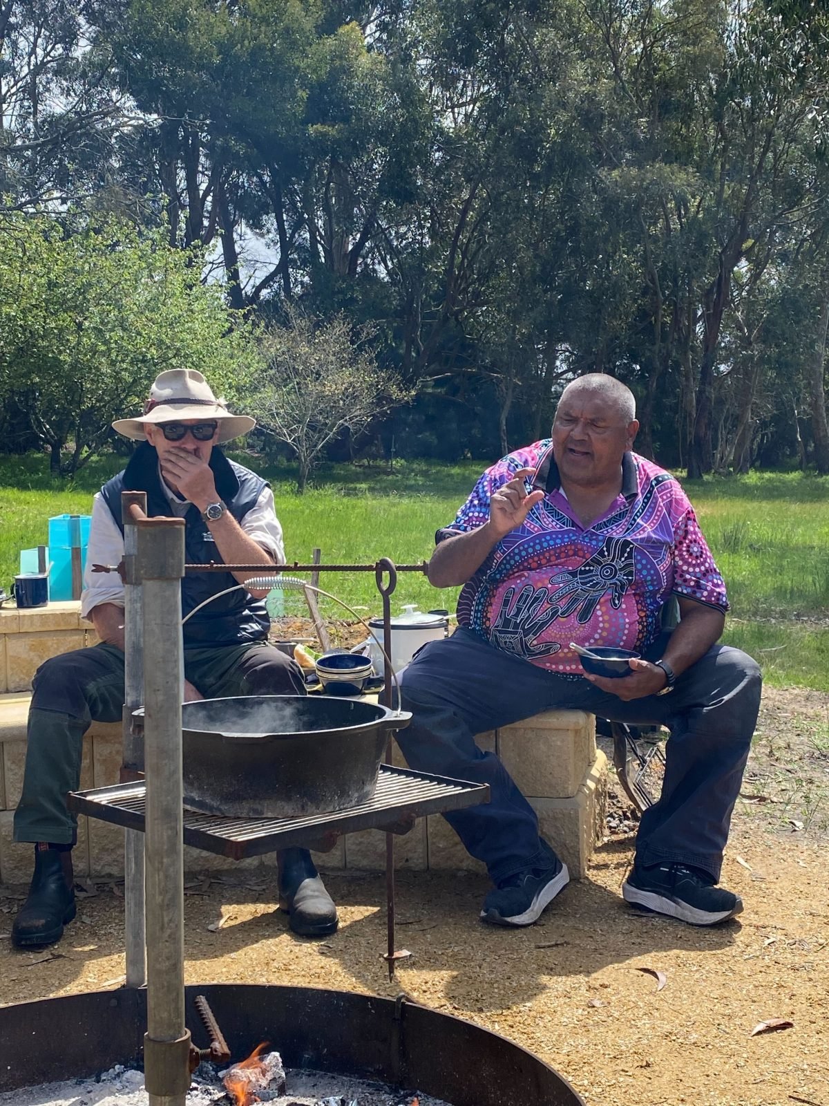 Two men, Mark and John are chatting by a fire