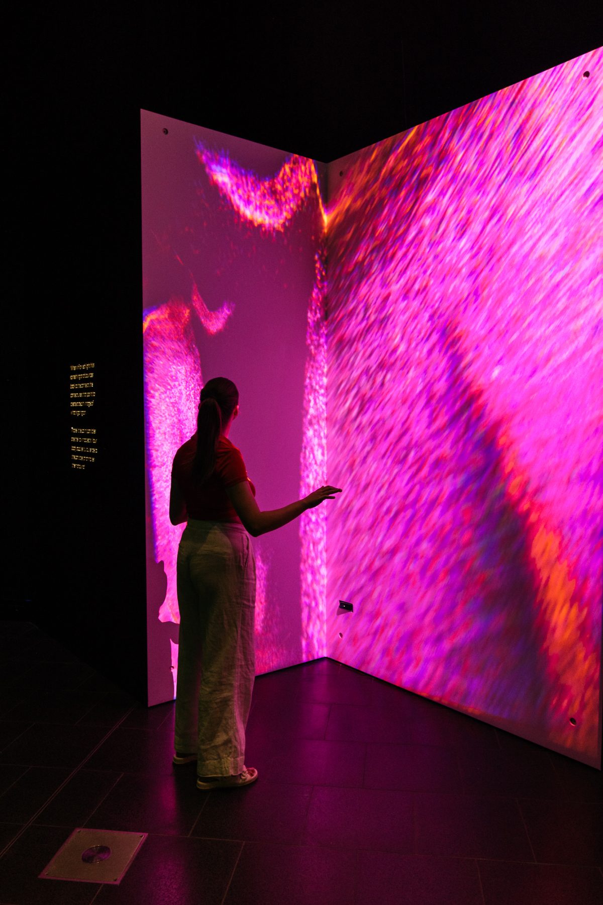 Visitor interacting with colourful projection
