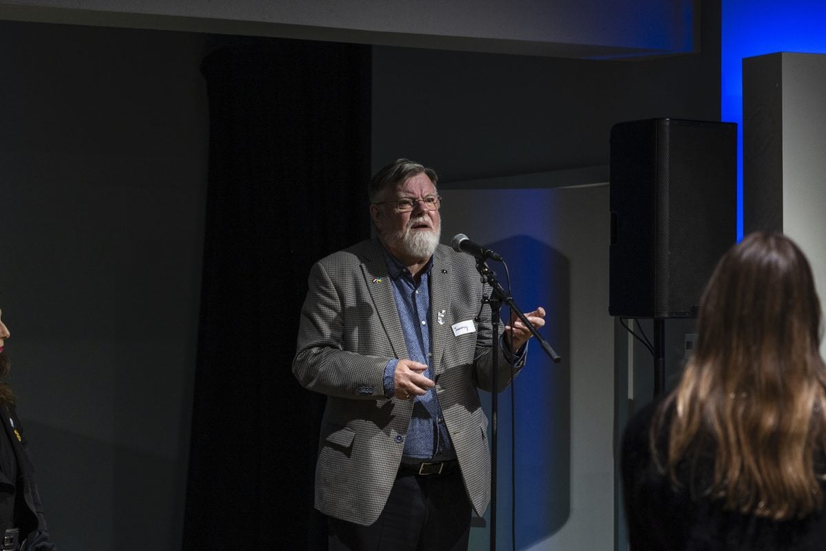 futurist-in-resident, Jeremy Bentham is standing behind a mircophone stand, confidently addressing our foresight community of practice