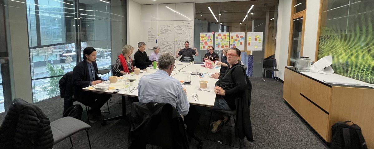 Workshop with people sitting around a square table