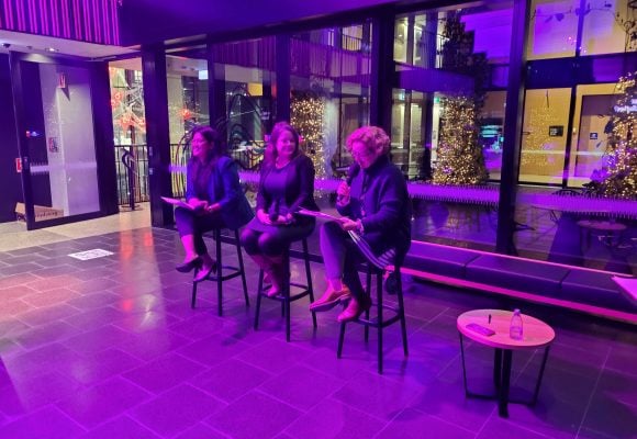 A panel of three women. On the left, Associate Professor Ruchi Sinha laughing. In the centre, Associate Professor Jenny Mortimer who faces Dr Kristin Alford sitting on the right, speaking into a microphone. 