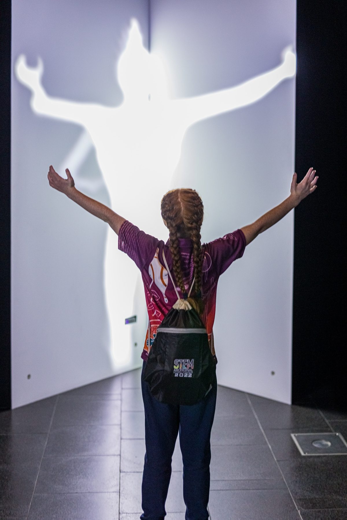 Student standing in front of a white light silhouette of herself