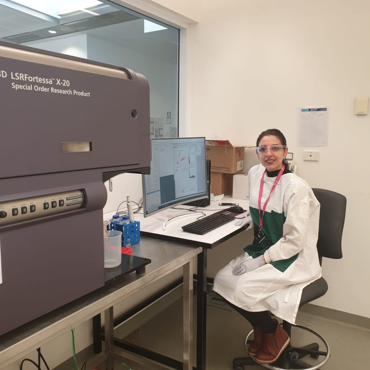 Parinaz Ahangar in lab coat at desk